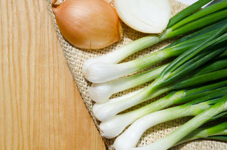 Onions and green onions on burlap, close-up. Very vitamin food.の写真素材