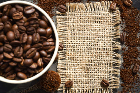 Coffee cone with ground coffee lie on coffee beans on burlap. Photo for advertising a coffee shop....