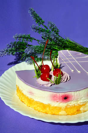 Cake with lavender, a mousse dessert with an exotic taste on a white plate on a purple background....
