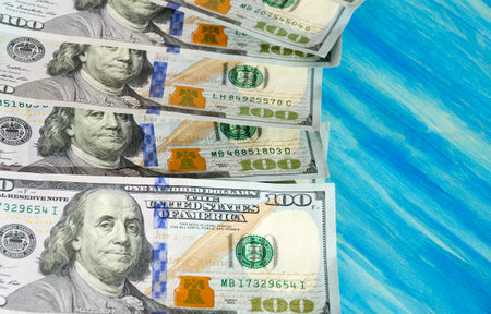100 dollar bills on a turquoise background. world currency