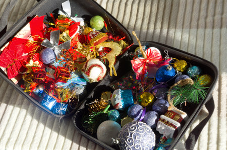 Box with Christmas decorations on the sofa. Lots of different toys for the Christmas tree.の写真素材