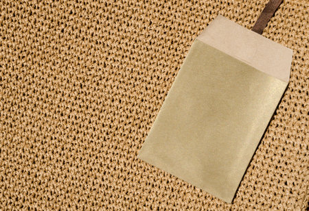 Paper envelope on a seamless knitted pattern. The background is crocheted with raffia threads.の写真素材
