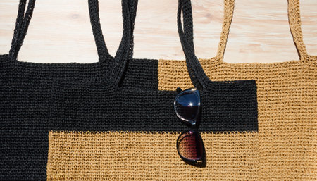 Three raffia beach bags. Women's bags with sunglasses on the table.の写真素材