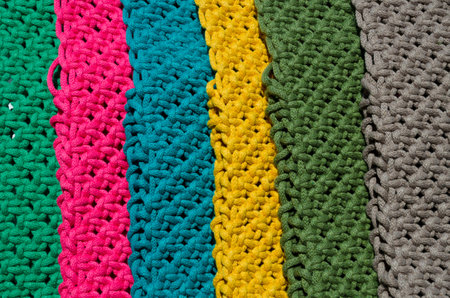 Macrame technique, a square knot of multi-colored threads. Colored macrame stripes in blue, yellow,...