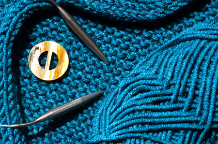Turquoise textured jersey is knitted on knitting needles from semi-woolen yarn. The concept of handmade, hobby, knitting fashion online course.の写真素材