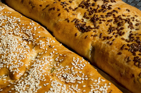 Meat pies. Baked rolls from yeast dough, sprinkled with sesame and flax seeds on parchment....