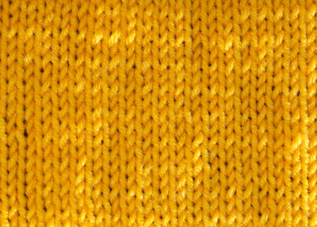 The texture of the satin stitch pattern is knitted with yellow wool yarn. Close-up sample of the pattern.の写真素材