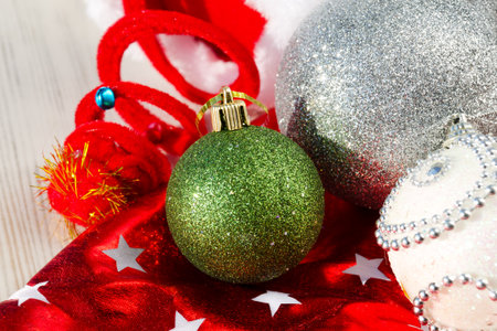 Decorations for the New Year and Christmas. Green ball, bows and stars, on a red background. A place for congratulations.の写真素材