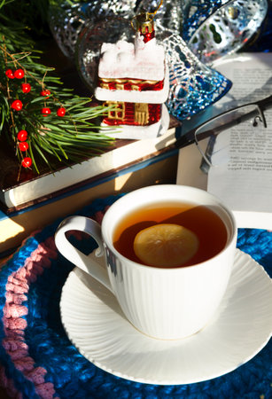 A cup of morning tea with lemon against the background of green Christmas tree branches. Decorations for the New Year and Christmas. A place for congratulations.の写真素材