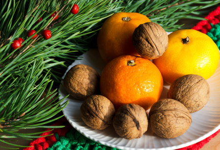 Tangerines and walnuts on a New Year's background. Decorations for the New Year and Christmas.の写真素材