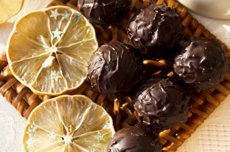 Chocolates for Valentine's Day. Dried lemon and dark chocolate candies on a wicker stand.の写真素材