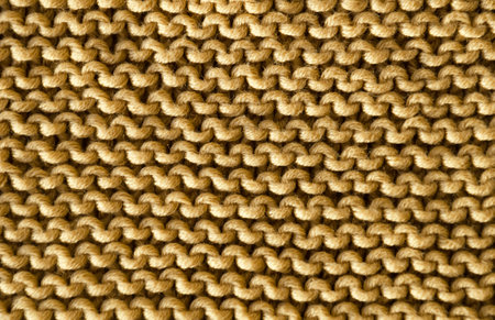 The beige garter stitch pattern is knitted with cotton yarn. Handmade concept, hobby, fashionable online knitting course.の写真素材
