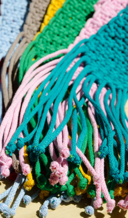 An example of the macrame technique, a square knot made of multi-colored threads. Colored macrame stripes in blue, yellow, beige, green and pink.の写真素材