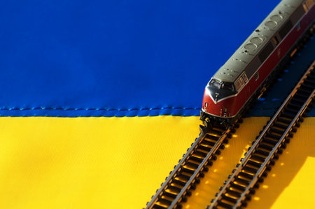 Ukrainian flag and locomotive model. Toy traction rolling stock on the Ukrainian flag.の写真素材