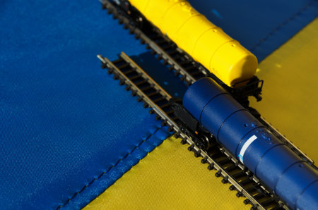 Against the background of the Ukrainian flag is a model of a railway with fuel tanks. Model train on the Ukrainian flag.の写真素材