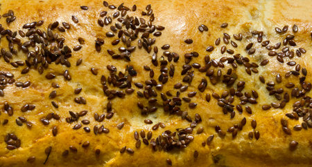 Meat pies. Baked rolls from yeast dough, sprinkled with sesame and flax seeds on parchment. Close-up, macro.の写真素材
