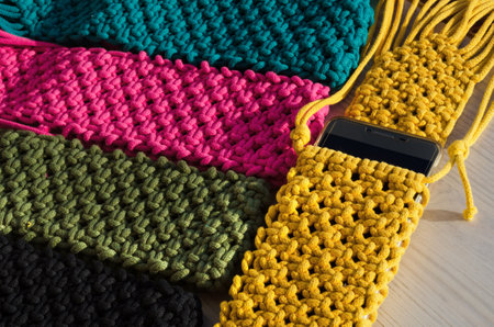Small handbag for a mobile phone. Knitting macrame, pattern of multi-colored cotton cords. Handmade concept, hobby, background, fashionable online knitting course.の写真素材
