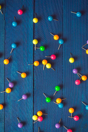 beautiful bright background of scattered colored round pins on wooden boards in blueの写真素材