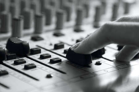 woman sets up the mixer to adjust the sound and recordingの写真素材