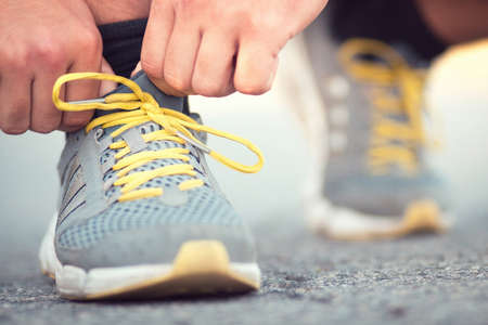 Runner tying shoelaces on sneakersの写真素材