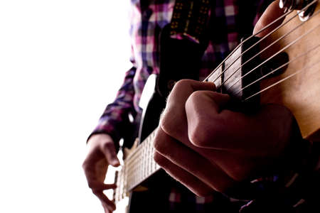 Hands of a young guy on strings playing electric guitar on white isolated backgroundの写真素材