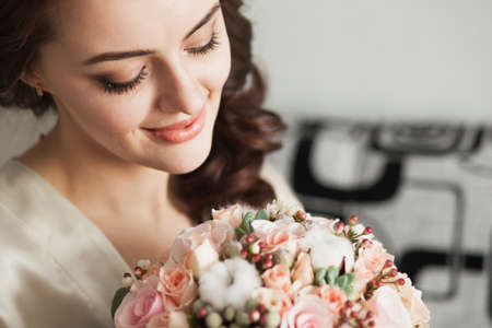 Beautiful young lady with soft make up and a bouquet of flowersの写真素材