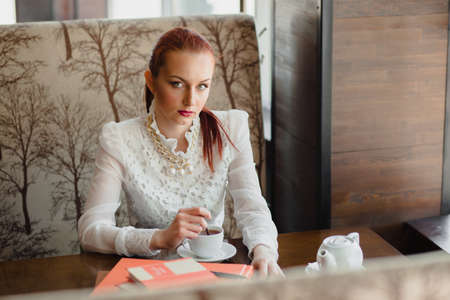 Beautiful girl in the cafe with books