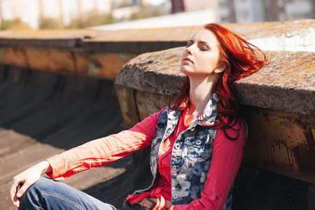 Beautiful redhair girl in casual on the rooftopの写真素材
