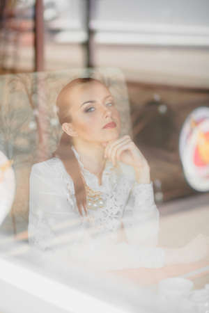 Beautiful girl in the cafe with booksの写真素材