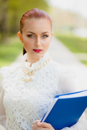 Beautiful girl with blue office folder outdoorの写真素材