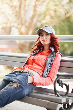 Beautiful redhair girl in casual on the benchの写真素材