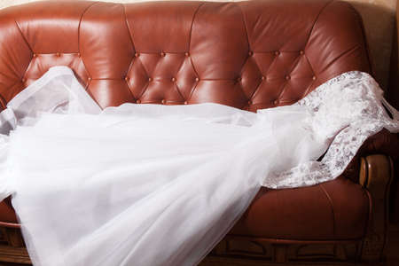 Wedding dress on the brown leather sofaの写真素材