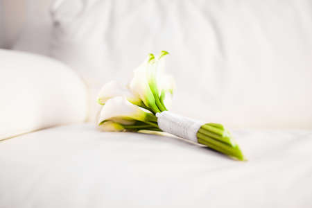 Beautiful bouquet of white lily on the white leather sofaの写真素材