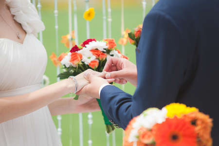 Groom put the wedding ring on bride's hand