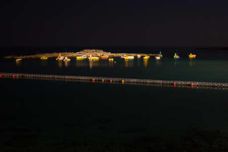 Small boats at sea shore at night uplitedの写真素材