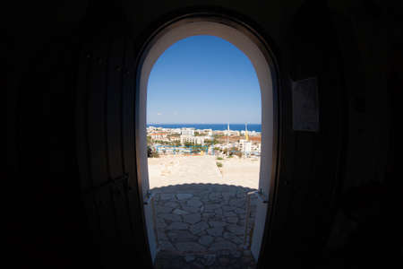 Town view on the seashore through the round door wayの写真素材
