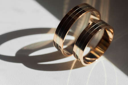 Golden wedding rings for bride and groom standing on the sidesの写真素材