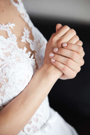 Bride's beautiful hands in fantastic white wedding dressの写真素材
