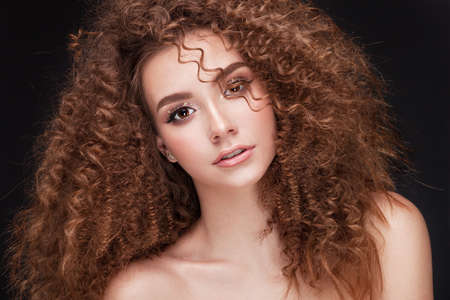 Very beautiful girl model with afro curls and soft skin in sudio on black backgroundの写真素材