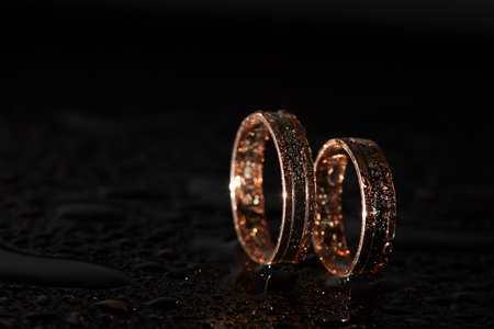 Golden wedding rings for bride and groom standing on the sidesの写真素材