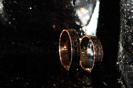 Golden wedding rings for bride and groom standing on the sidesの写真素材