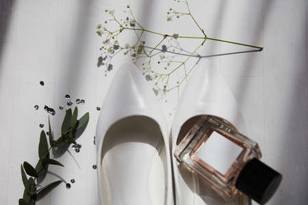 Wedding bride's elements such as shoes and perfume on the table on the striped backgroundの写真素材
