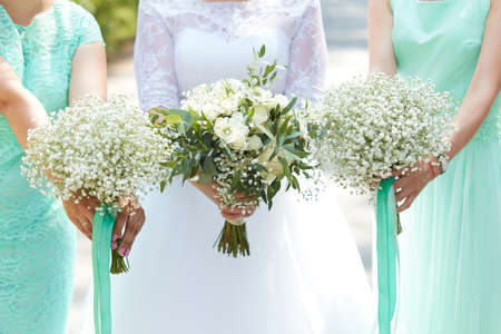 Bride and bridesmaids holding in their hands bouquets of flowersの写真素材