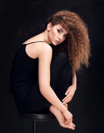 Very beautiful girl model with afro curls fashion posing in sudio on black backgroundの写真素材