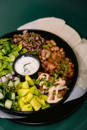 Burrito bowl food. brown rice, beans, meat, fresh vegetables and sauce.の写真素材