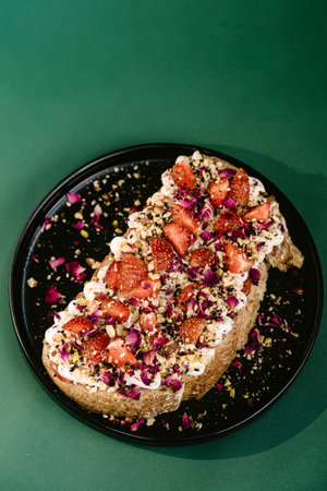 toasted bread dish topped with soft ricotta cheese and sprinkled with fresh strawberry slicesの写真素材