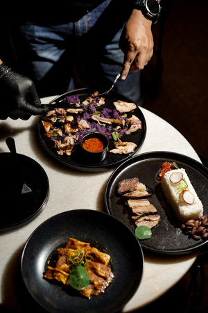 chef is serving chicken and spices on the dining table, grilled fish, riceの写真素材