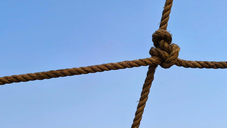 tied rope against bright blue cloudy sky backgroundの写真素材