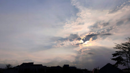 beautiful sunset view in a cloudy sky in the evening with houses below, panoramaの写真素材