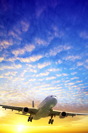 Jet in a sky at sunset time. Vertical shot.の写真素材